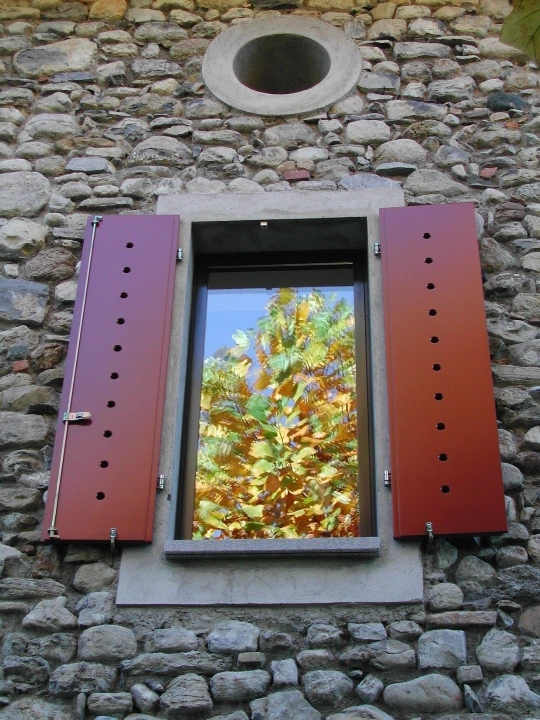 Dettaglio di finestra con gelosie metalliche aperte