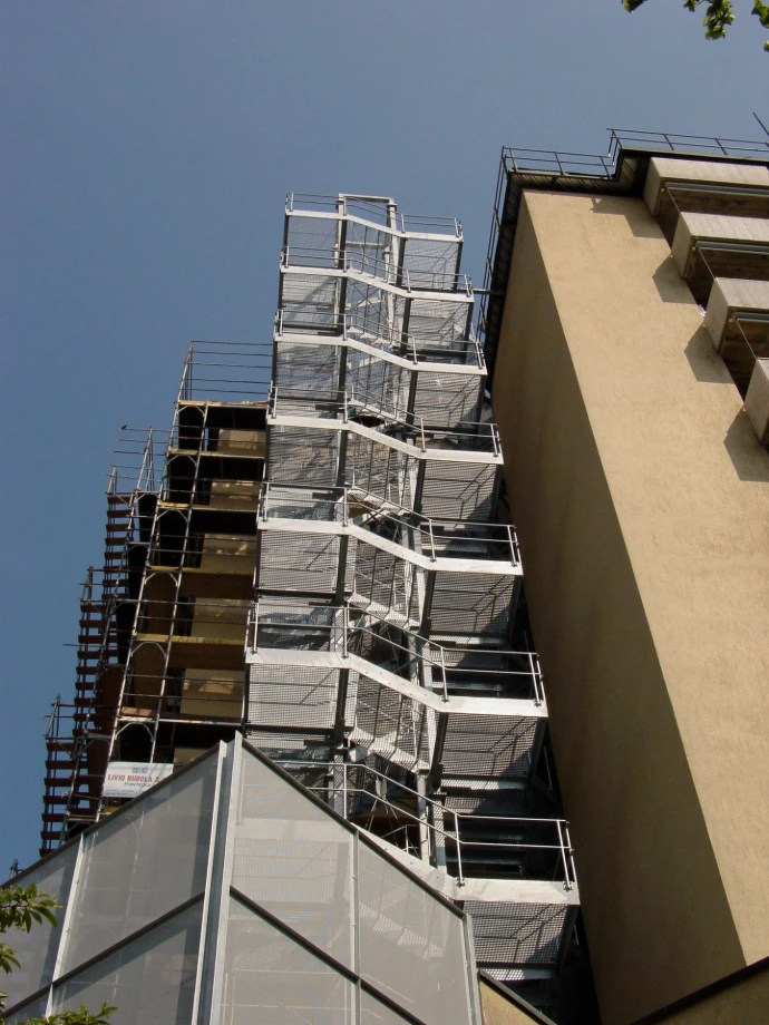 Scala metallica esterna a più rampe affiancata a un edificio – Giugni SA